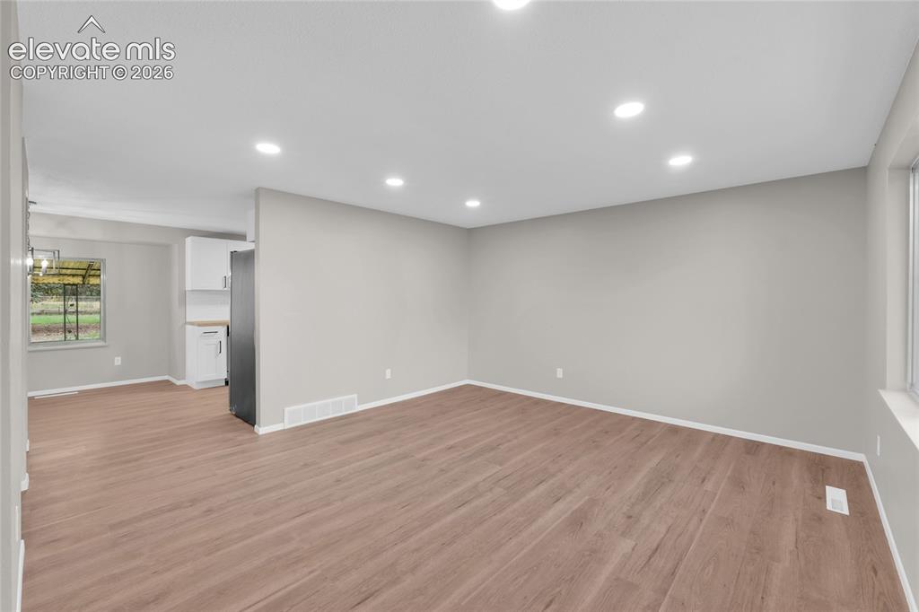 Image 5 of 29: Wood-finish flooring, recessed lighting, white trim, light grey wall paint,