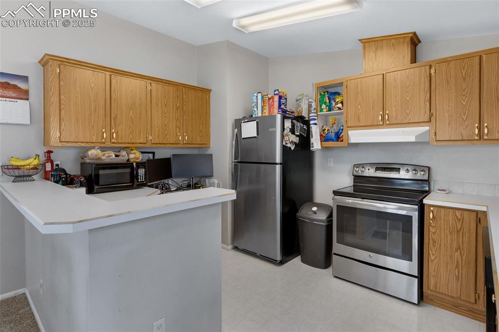 Image 10 of 24: Kitchen with light countertops, a peninsula, stainless steel appliances, an