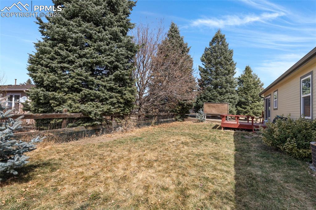 Image 23 of 24: View of yard with a wooden deck and fence