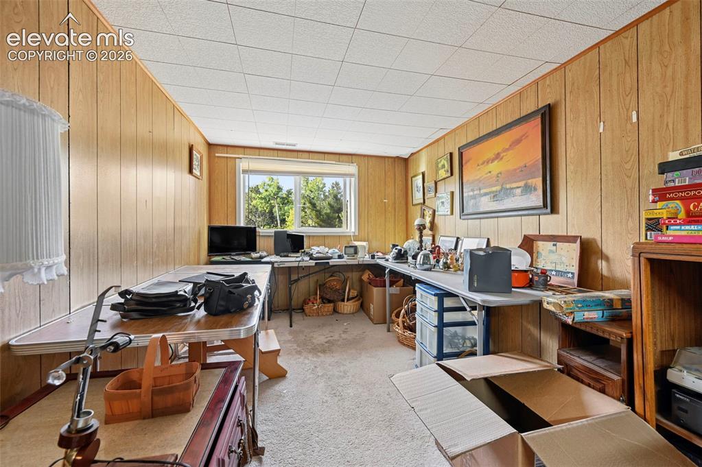 Image 13 of 29: Recessed window, wood-finish wall paneling, drop ceiling, and carpeted floo