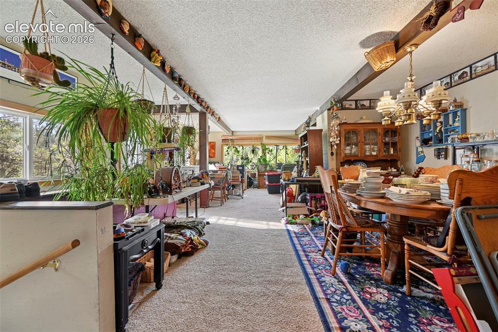 Image 16 of 29: Exposed ceiling beams, recessed windows, and wood-finish flooring