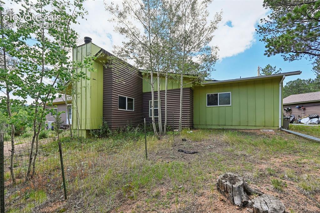 Image 25 of 29: Side exterior featuring vertical green siding and horizontal brown siding