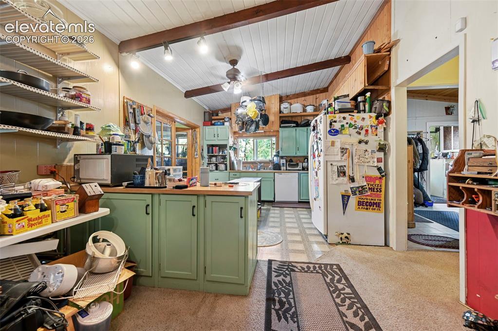 Image 8 of 29: Vaulted ceiling with exposed wood beams, wood-paneled walls, light green ca