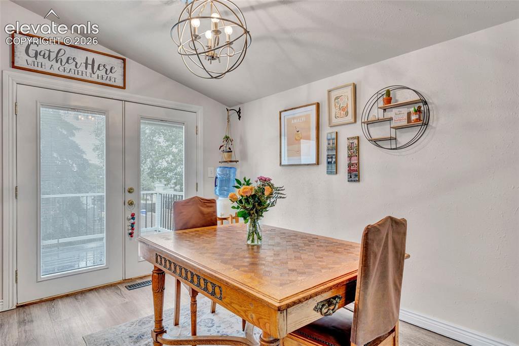 Image 10 of 44: Vaulted ceiling room featuring French doors, wood-finish flooring, and a co