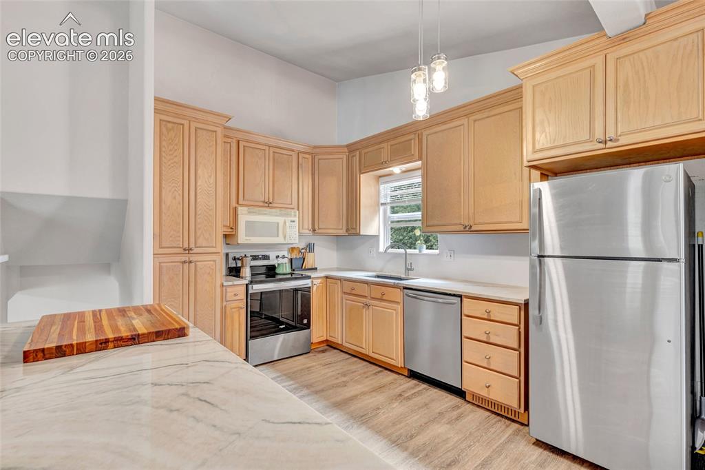 Image 11 of 44: Kitchen featuring light wood cabinetry, stainless steel appliances, a windo