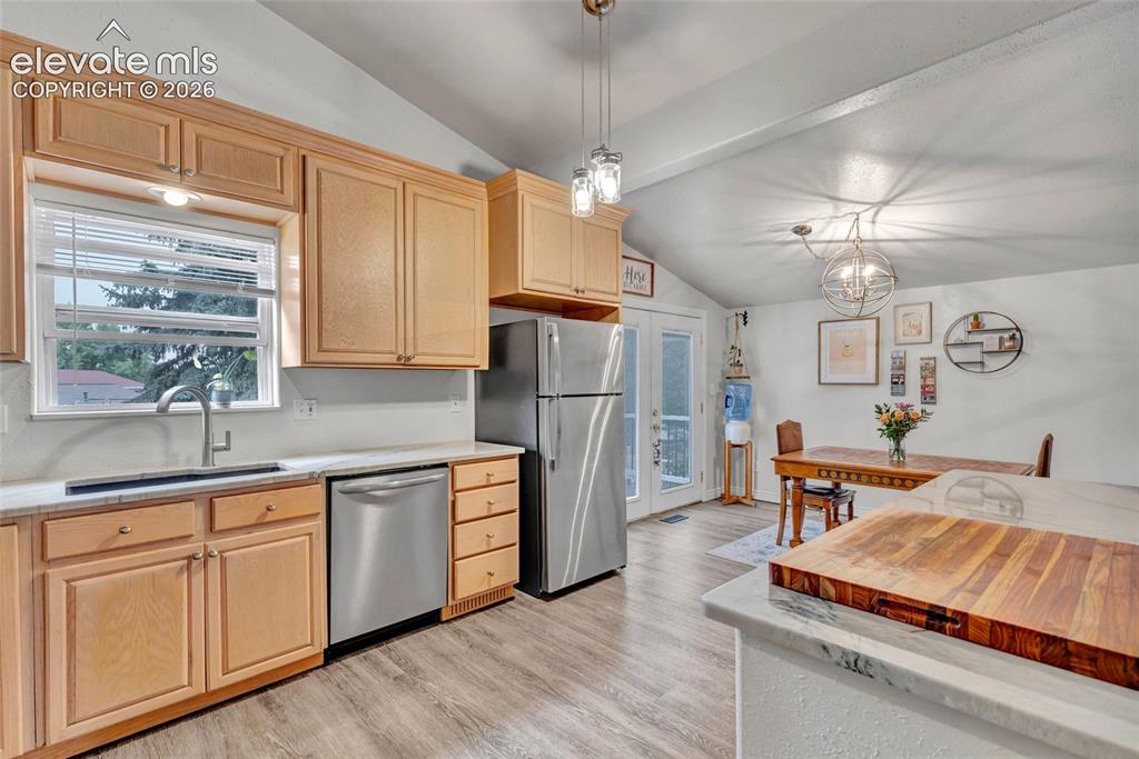 Image 15 of 44: Kitchen featuring wood-finish cabinetry, stainless steel appliances, and li