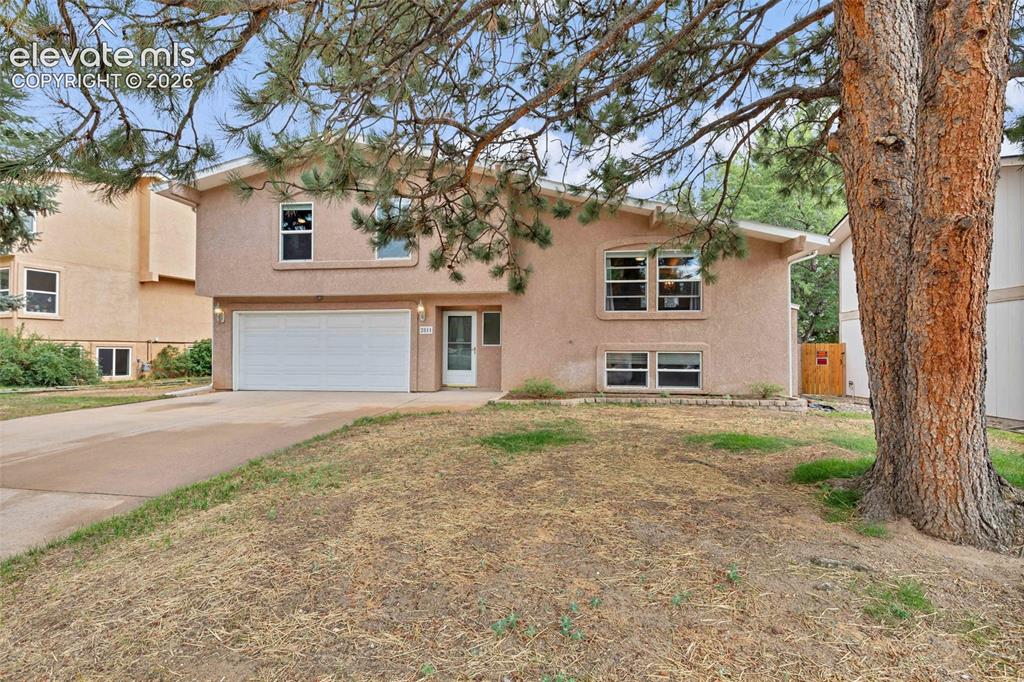 Image 2 of 44: Stucco exterior featuring a two-car garage, front entry with storm door, an