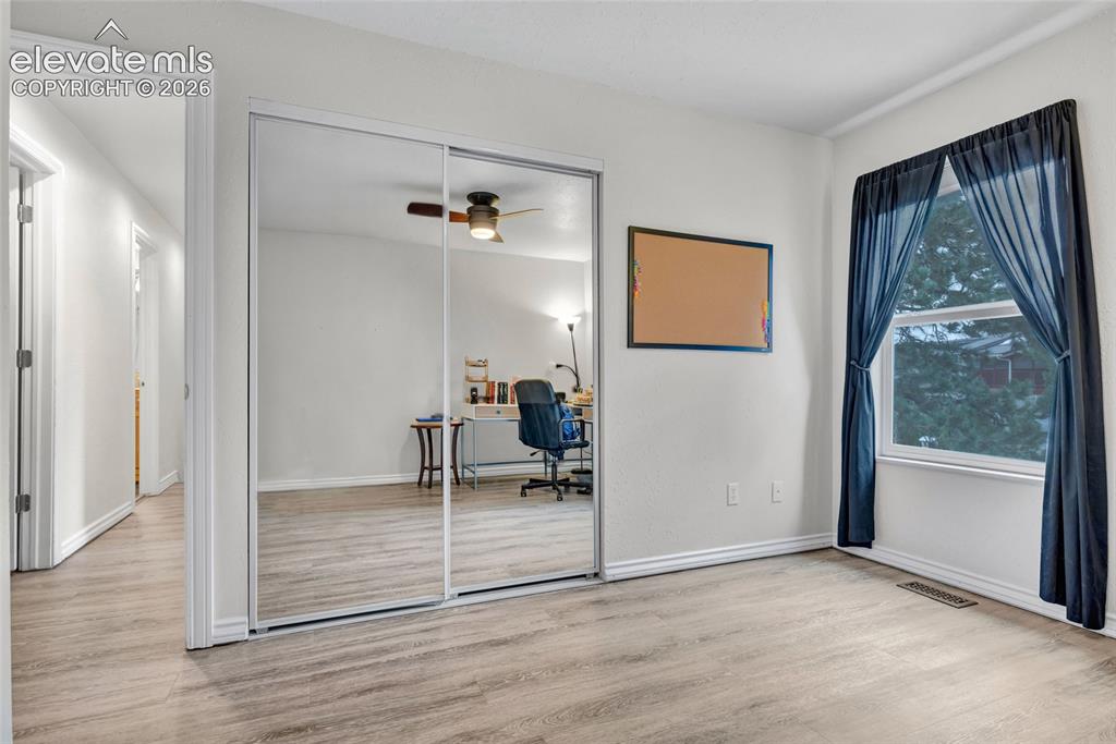 Image 20 of 44: Bedroom featuring wood-finish flooring, a double window, and white trim