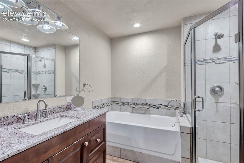 Image 23 of 44: Bathroom featuring a dark wood-finish vanity with a single basin, granite c