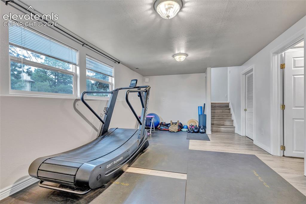 Image 26 of 44: Spacious room featuring light wood-finish flooring, white walls, and multip