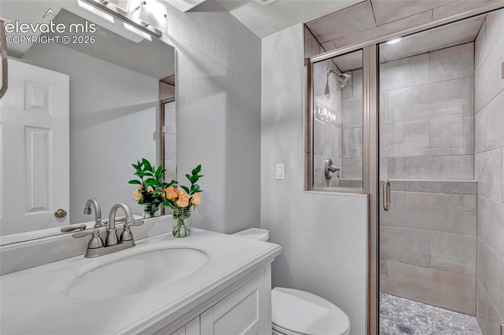 Image 30 of 44: Bathroom featuring a white vanity with integrated sink, brushed nickel fauc
