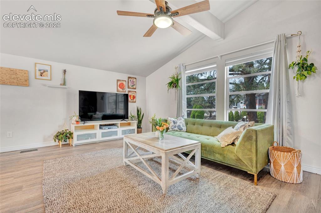 Image 6 of 44: Vaulted ceilings with exposed beams and a ceiling fan, wood-finish flooring