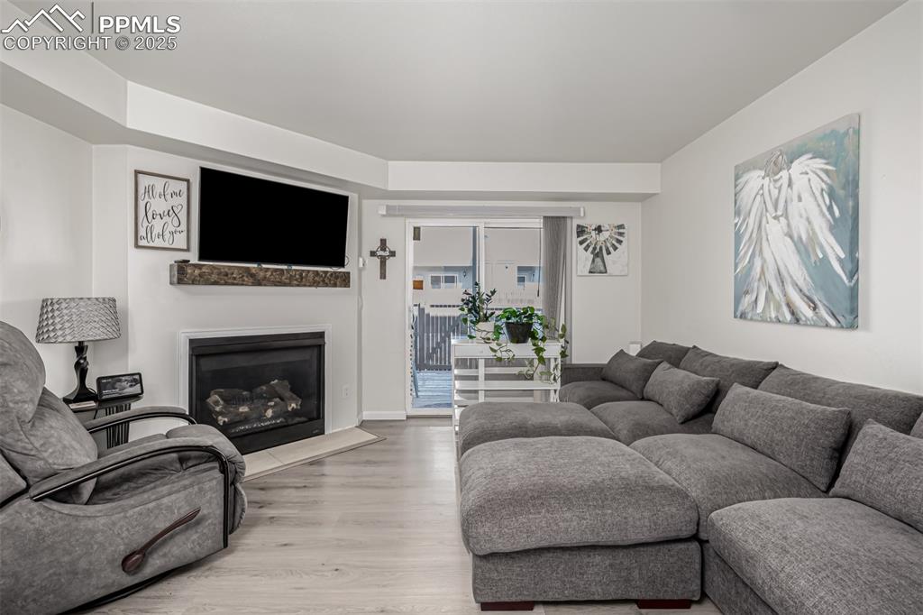 Image 14 of 47: Living room with a fireplace and light wood-style flooring