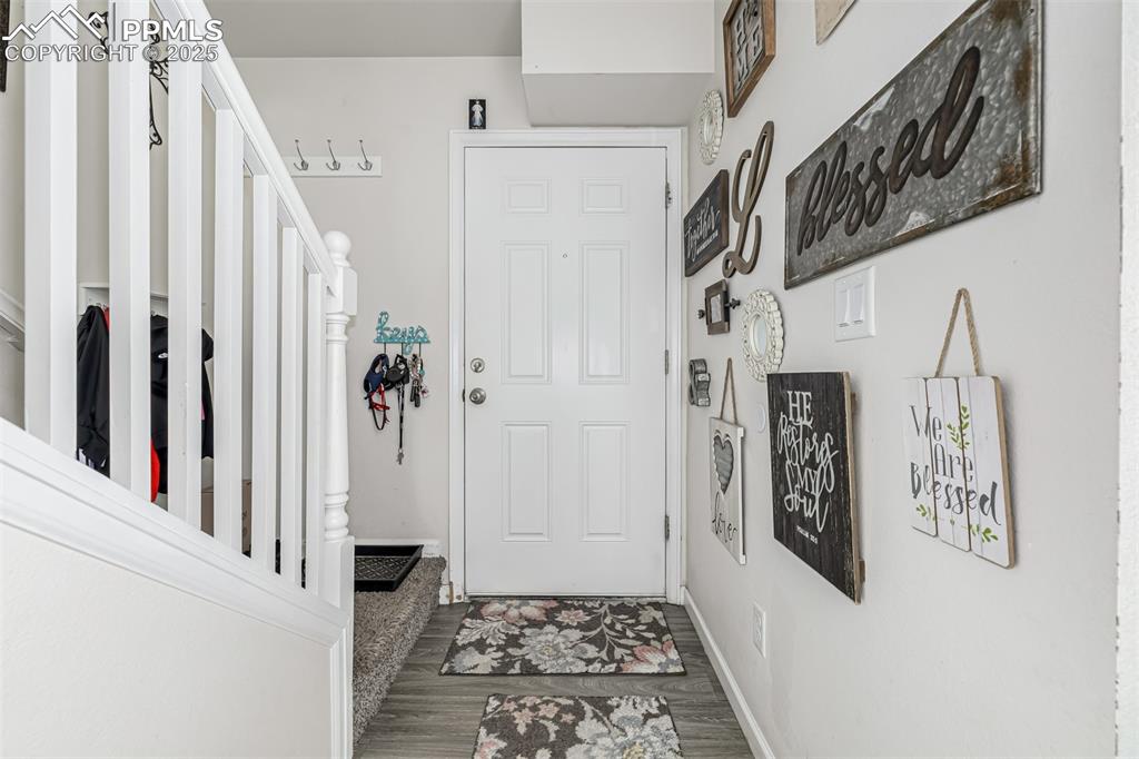 Image 7 of 47: Foyer with stairs and wood finished floors