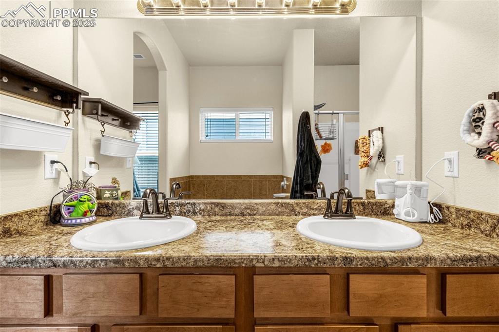 Image 21 of 31: Primary bathroom has dual sinks, smooth counters and plenty of cabinet spac