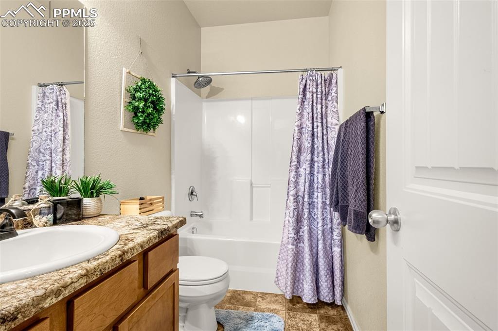 Image 22 of 31: Shared bathroom with smooth counters, storage and shower/tub combo.