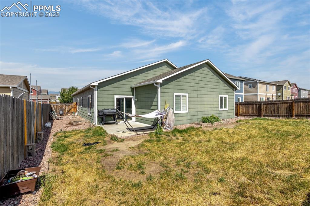 Image 25 of 31: Rear view of house with a fenced backyard, a patio area, and area ready to 