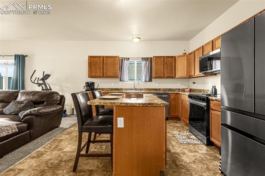 Image 8 of 31: Kitchen with open floor plan, appliances with stainless steel Samsung Bespo
