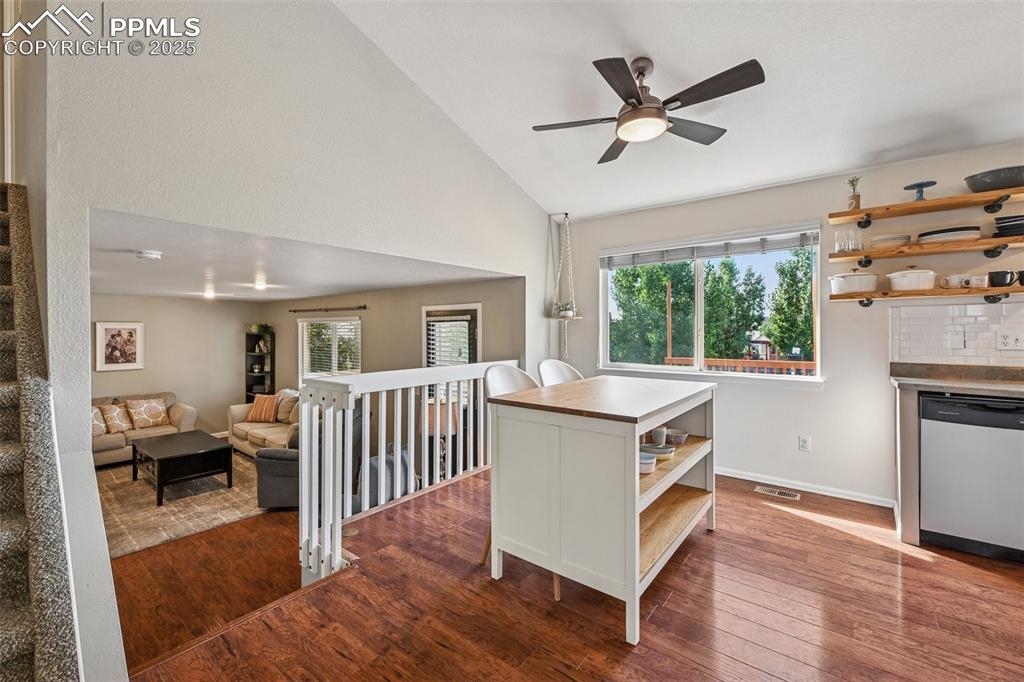 Image 10 of 38: Kitchen with open shelves, dark wood-style flooring, stainless steel dishwa