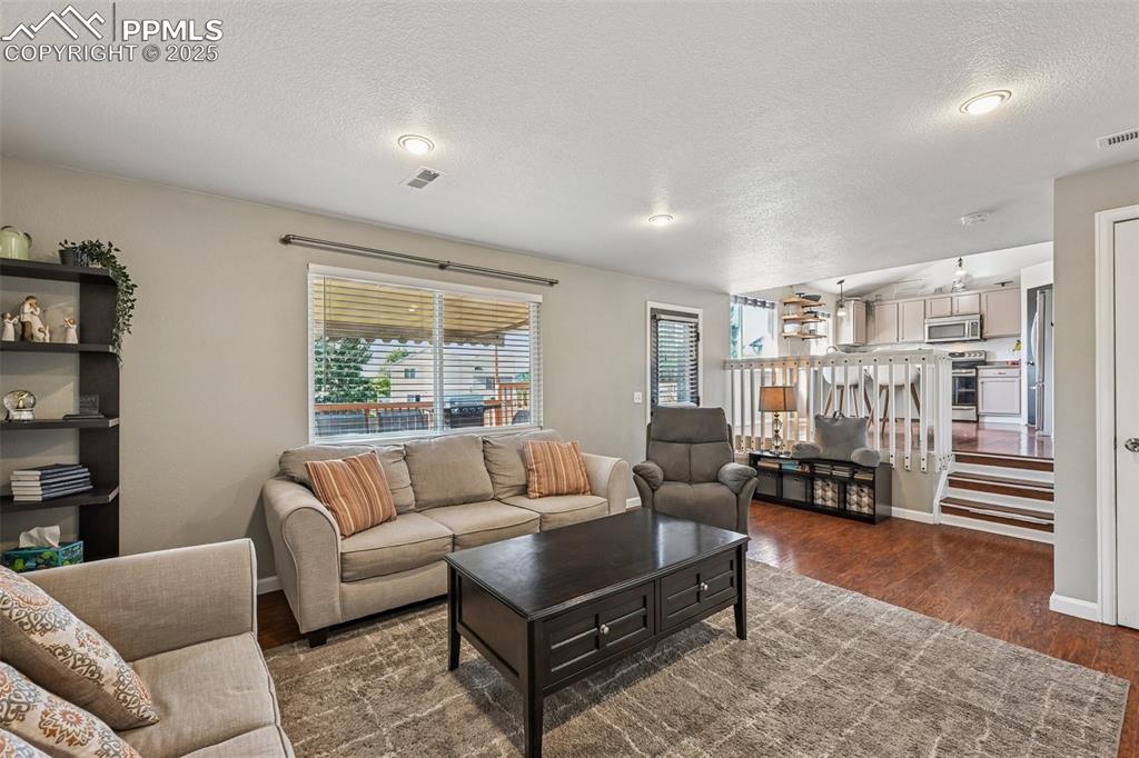 Image 11 of 38: Living area featuring dark wood-type flooring and a textured ceiling