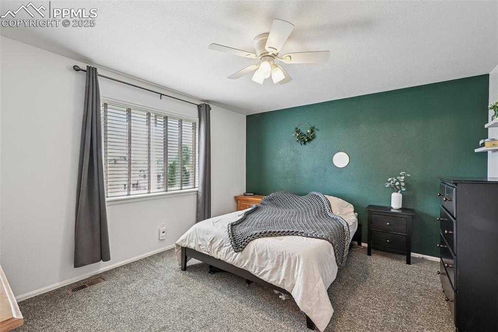 Image 14 of 38: Bedroom with light colored carpet and ceiling fan