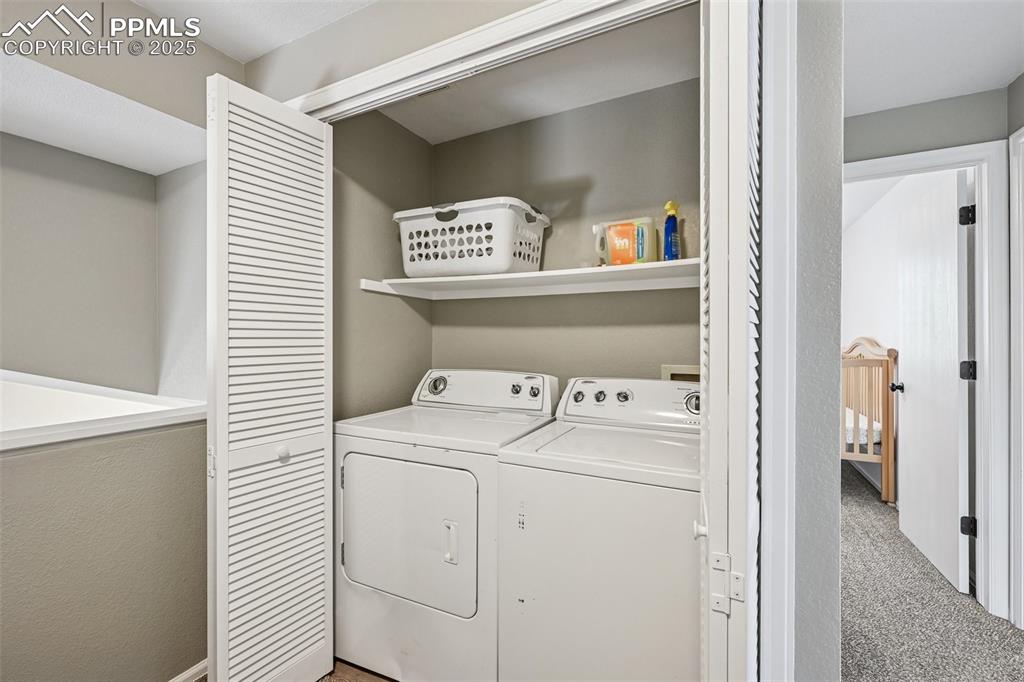 Image 17 of 38: Washroom featuring washer and dryer and light colored carpet