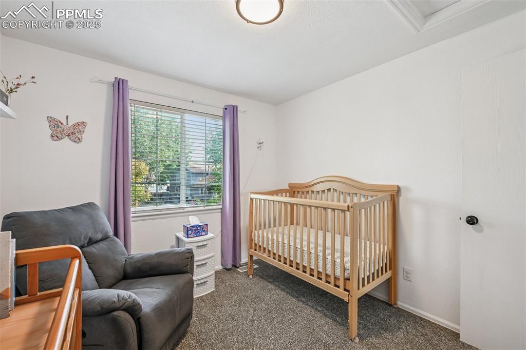 Image 19 of 38: Carpeted bedroom with a nursery area