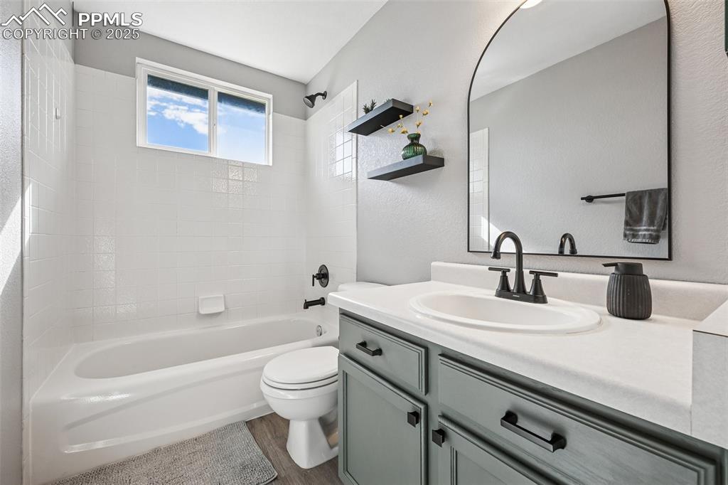 Image 20 of 38: Full bath with shower / bathtub combination, vanity, a textured wall, and d