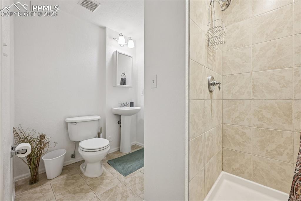 Image 27 of 38: Bathroom featuring a shower stall and tile patterned floors
