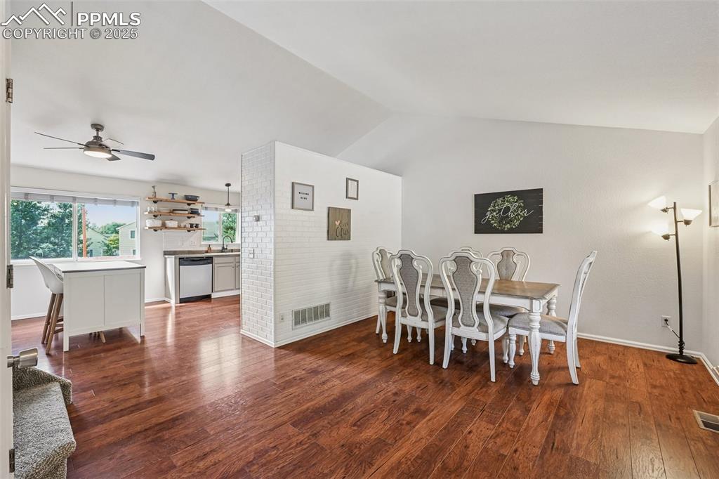 Image 6 of 38: Dining area featuring dark wood finished floors, vaulted ceiling, and ceili