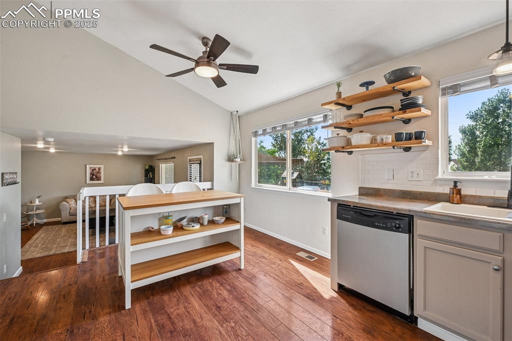 Image 9 of 38: Kitchen with open shelves, dark wood-type flooring, stainless steel dishwas