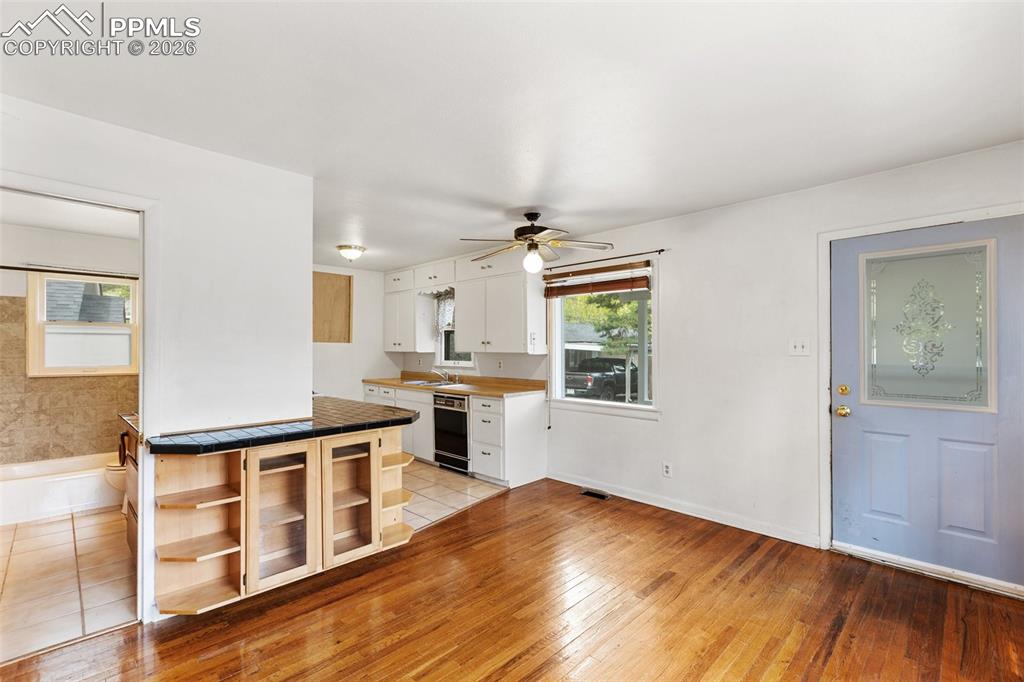 Image 13 of 49: Living room features real wood flooring, built-in cabinetry and it is open 