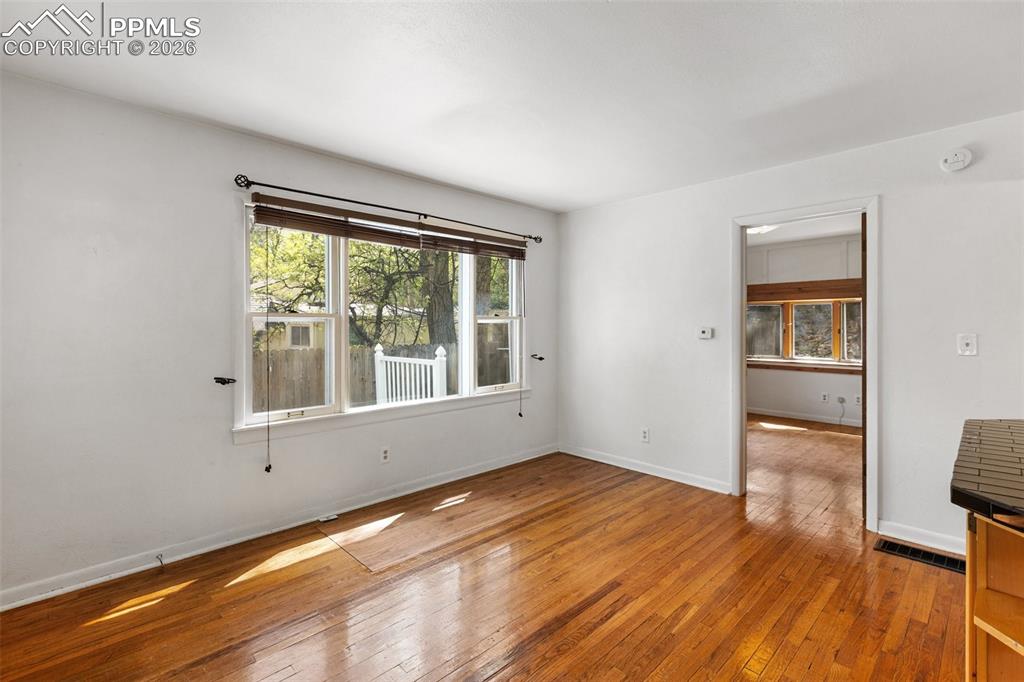 Image 15 of 49: Main level living room features real wood flooring.  You