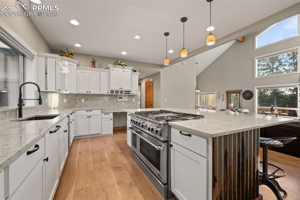 Image 13 of 50: Bright open kitchen with commercial gas stove and range 6 burners and gridd