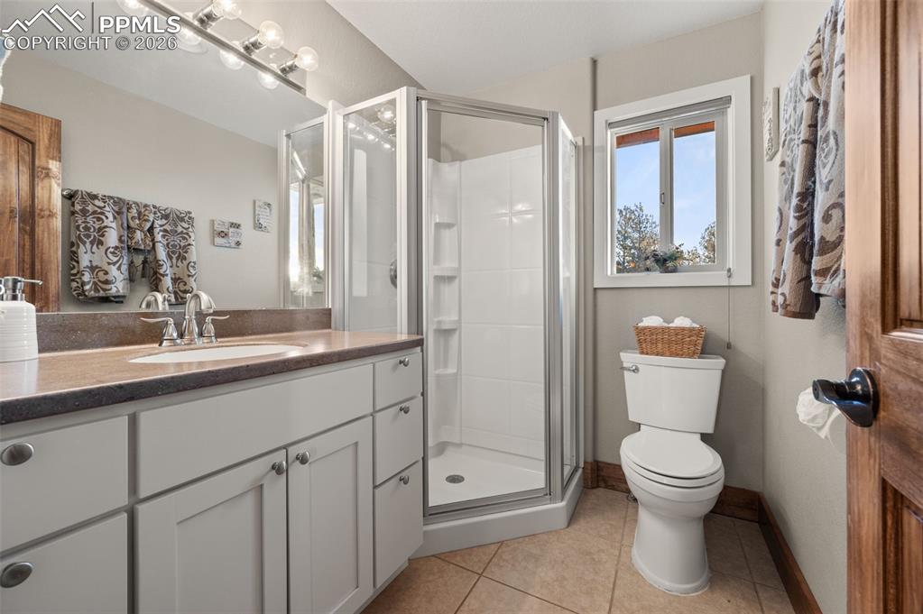 Image 24 of 50: Main floor bathroom next to bedroom and laundry room with a shower.