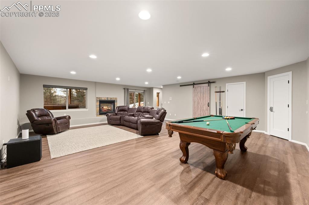 Image 29 of 50: Game room or Family room in the walk out basement with fireplace. Walk out