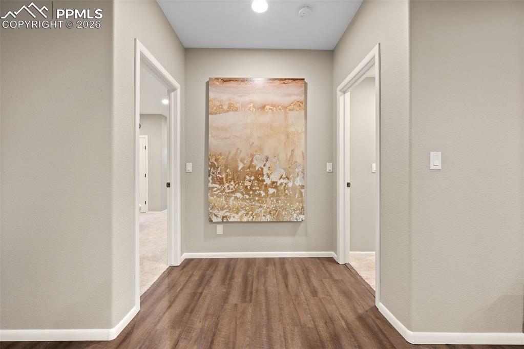 Image 30 of 50: Hallway access to the two bedrooms on lower level with all new LVP flooring