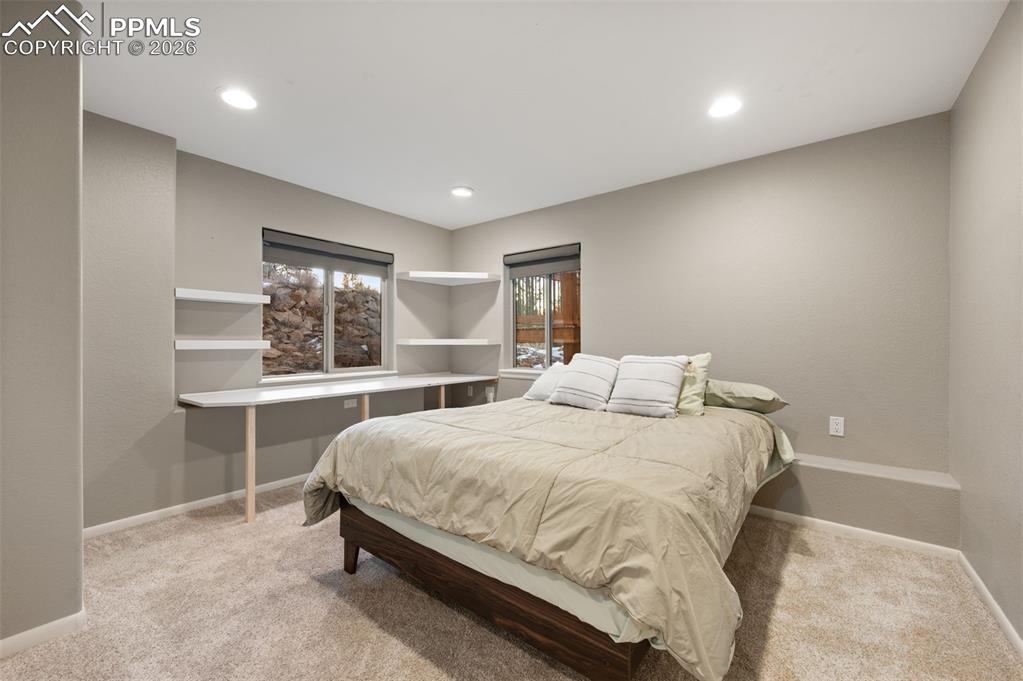 Image 31 of 50: Lower level bedroom that connects to large separate vanity and sink and the