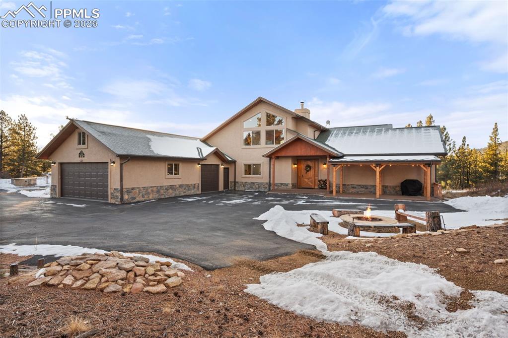 Image 4 of 50: Front of home with view of side load garage and generous parking