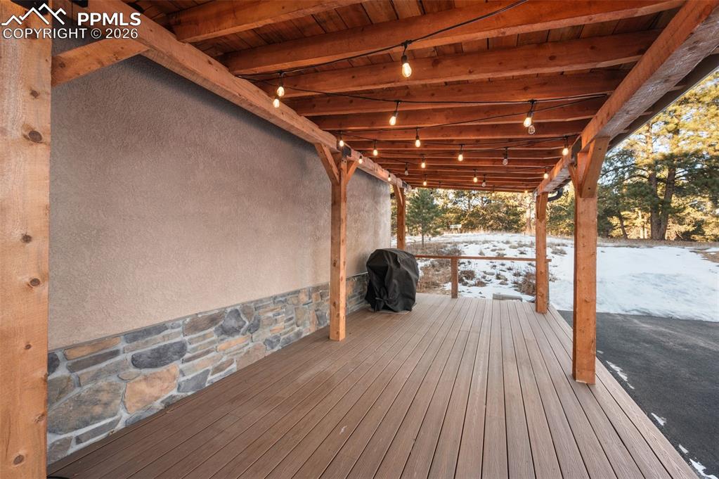 Image 6 of 50: Front covered patio with heated roof and gutters