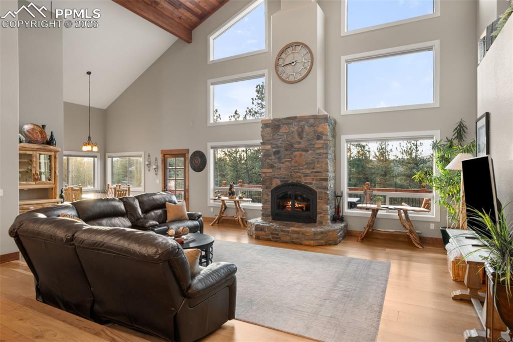 Image 8 of 50: Living room with 2 story windows, beautiful views and wood burning fireplac