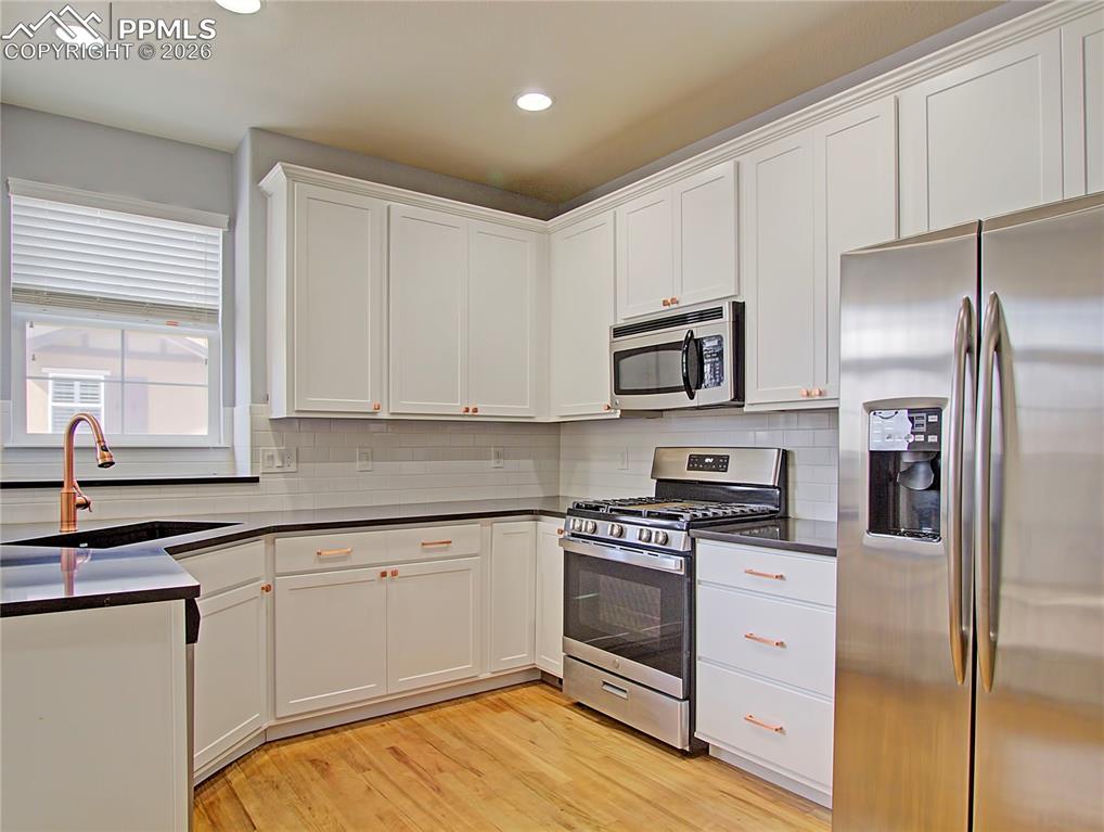 Image 12 of 27: Kitchen featuring stainless steel appliances, light wood-style floors, whit