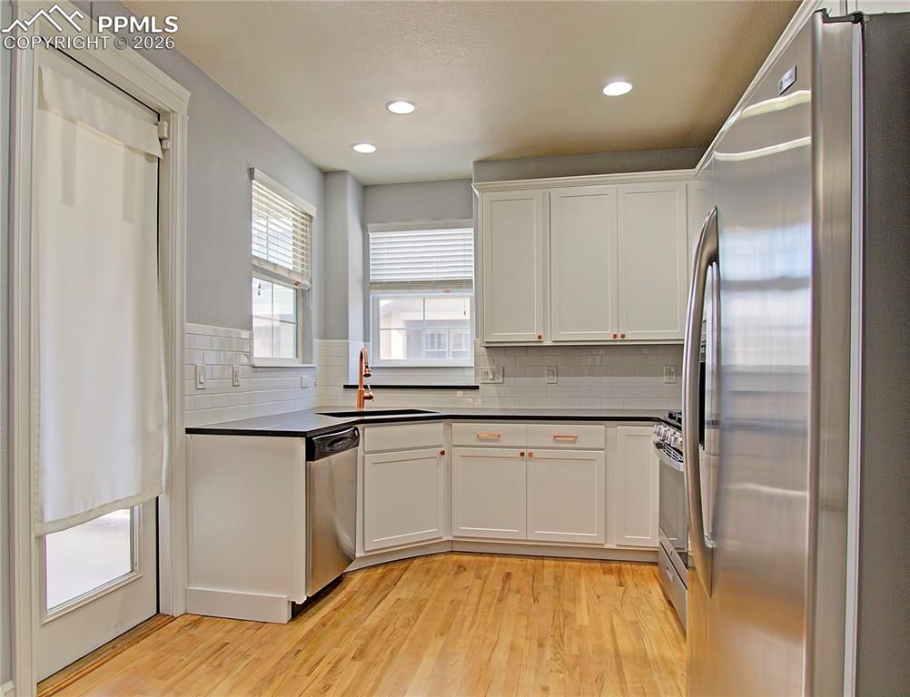 Image 13 of 27: Kitchen featuring stainless steel appliances, light wood-type flooring, whi