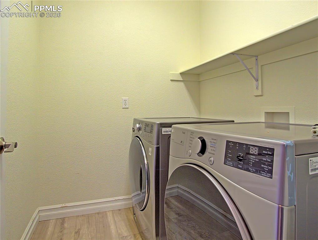 Image 20 of 27: Laundry area with light wood-type flooring, independent washer and dryer, a