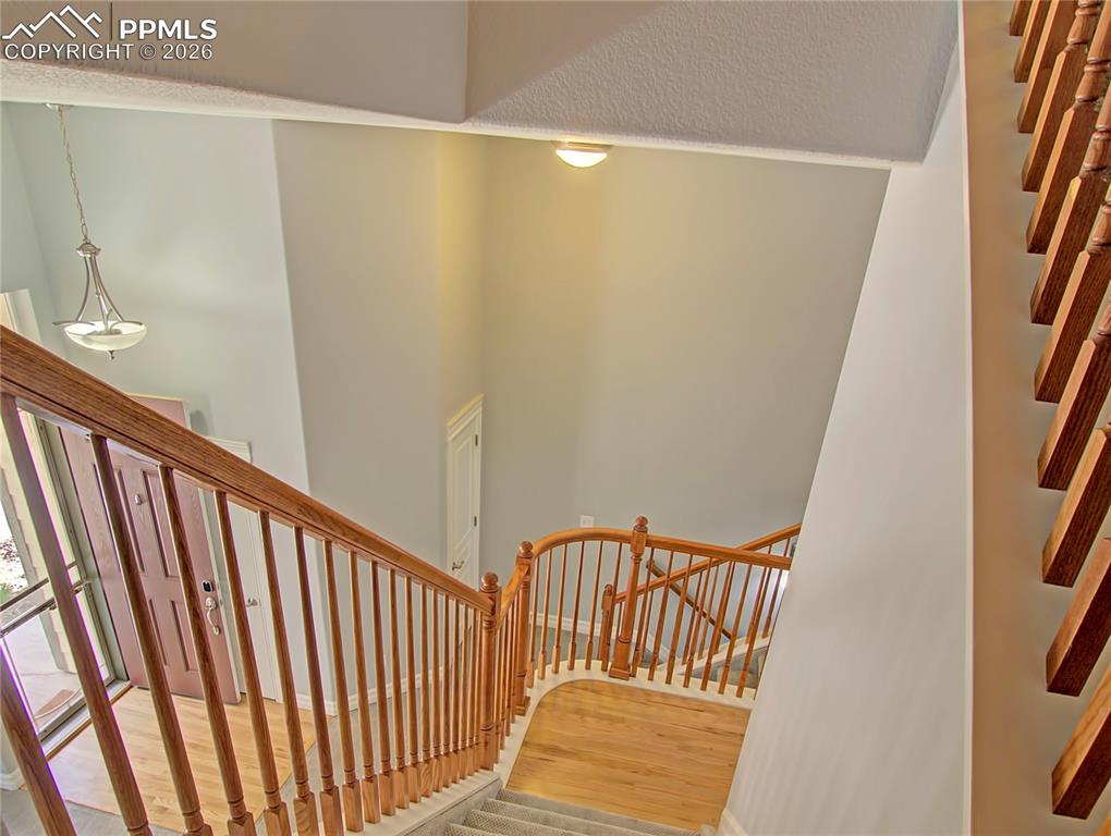 Image 23 of 27: Staircase with a high ceiling and wood finished floors