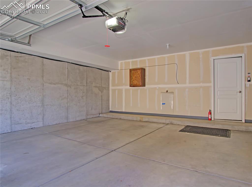 Image 25 of 27: Garage featuring a garage door opener