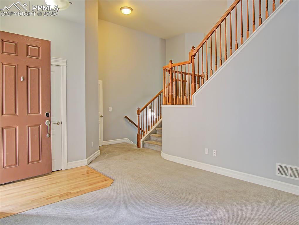 Image 5 of 27: Entryway with stairs and light colored carpet