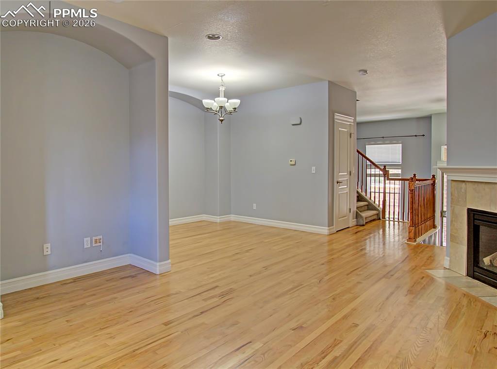 Image 9 of 27: Unfurnished living room with light wood-type flooring, a fireplace, and han