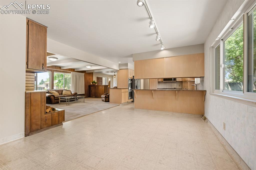 Image 12 of 50: Kitchen featuring light floors, a kitchen bar, open floor plan, a peninsula