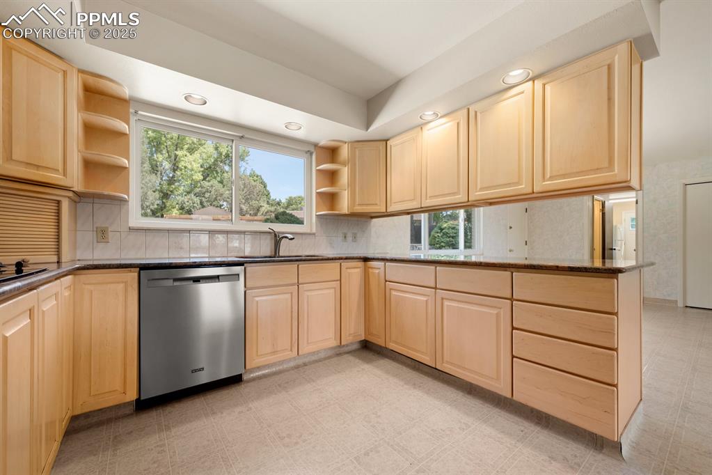 Image 14 of 50: Kitchen with open shelves, light floors, light brown cabinetry, recessed li
